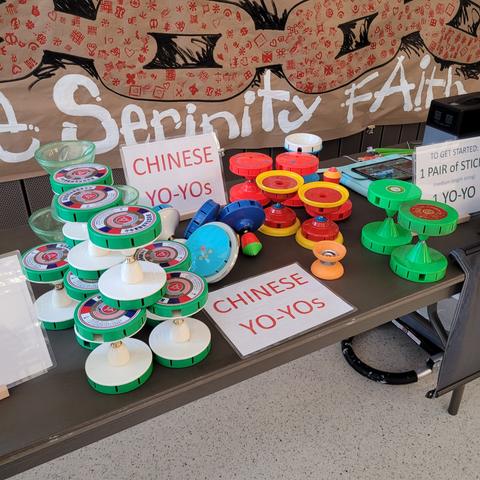 Table full of colorful Chinese yo-yos at an indoor booth